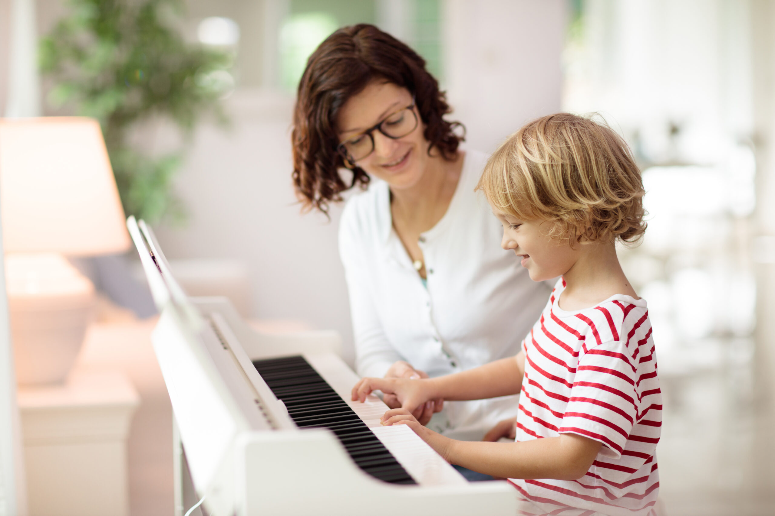 a woman and child playing piano