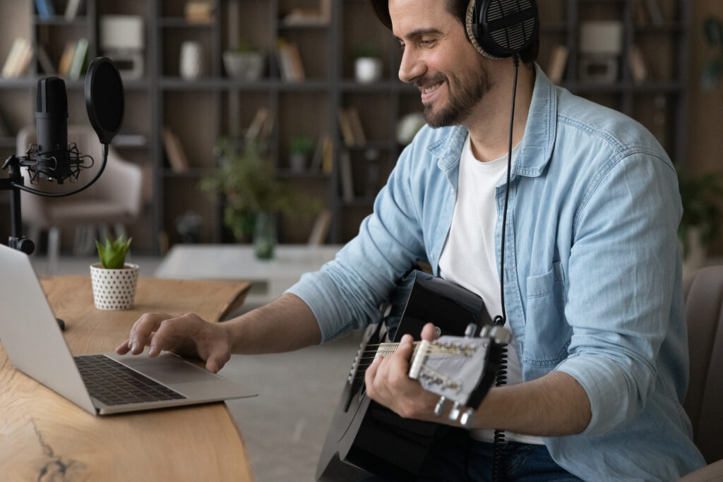 Happy millennial man musician hold play guitar