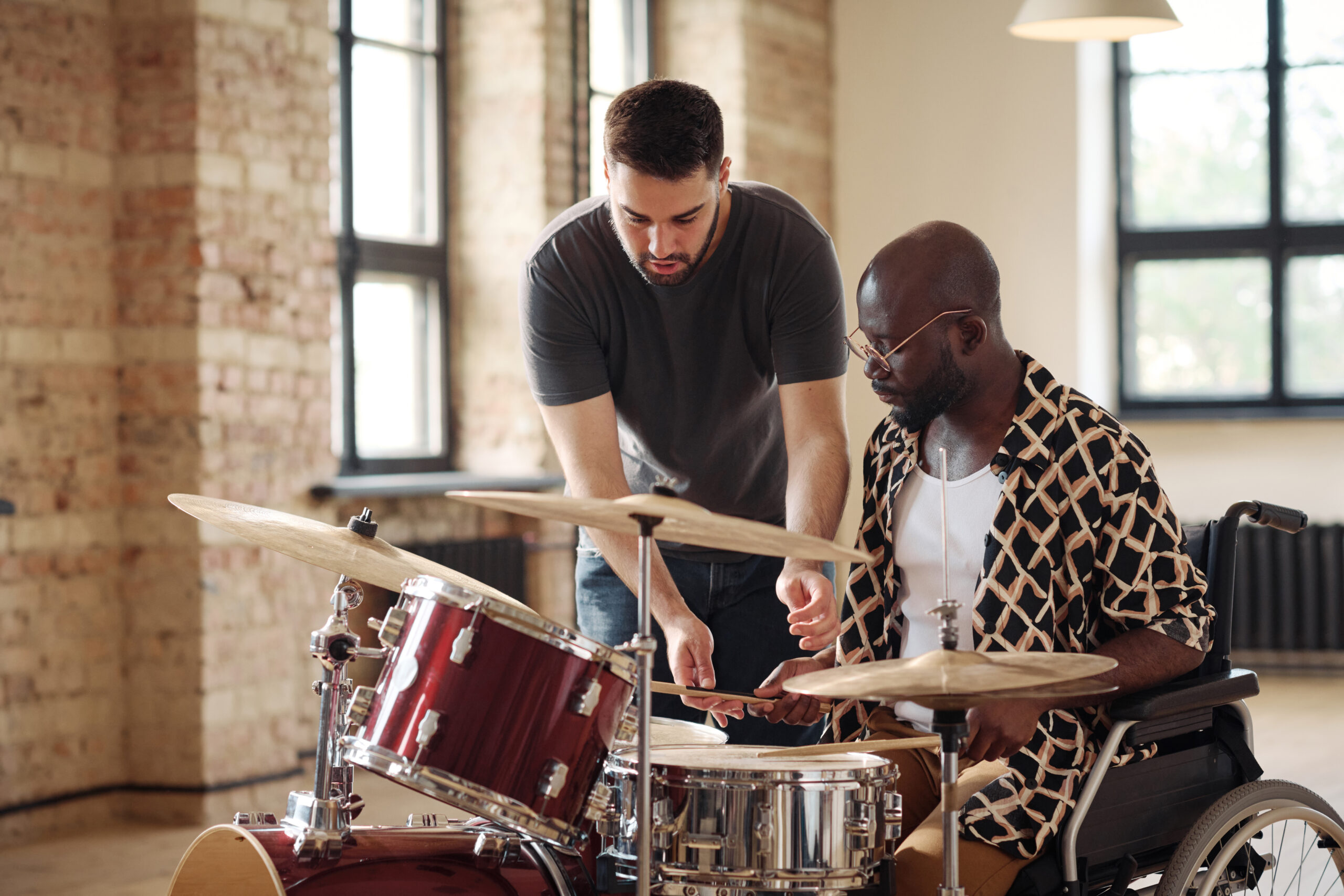 Drum Instructor teaching an adult male to play drums