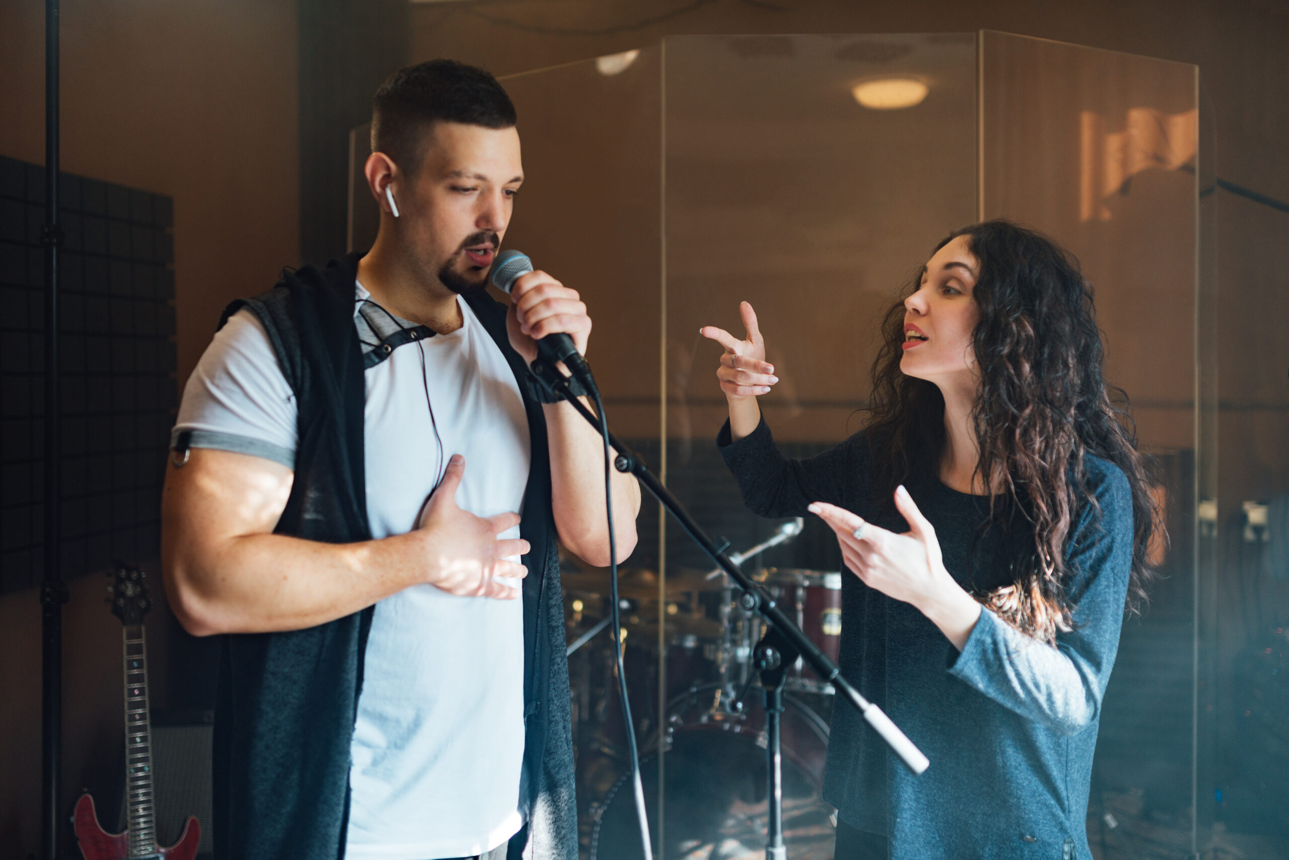 a man does chanting with a teacher in vocal lesson pointing to the correct breathing in the chest