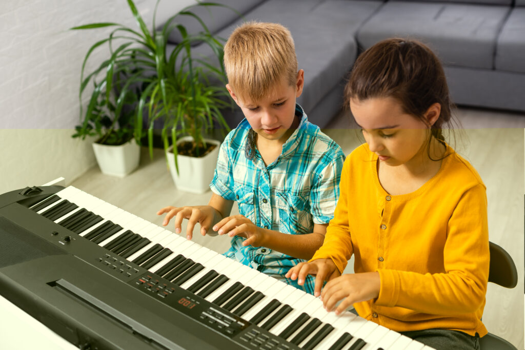 2 children learning to play the piano