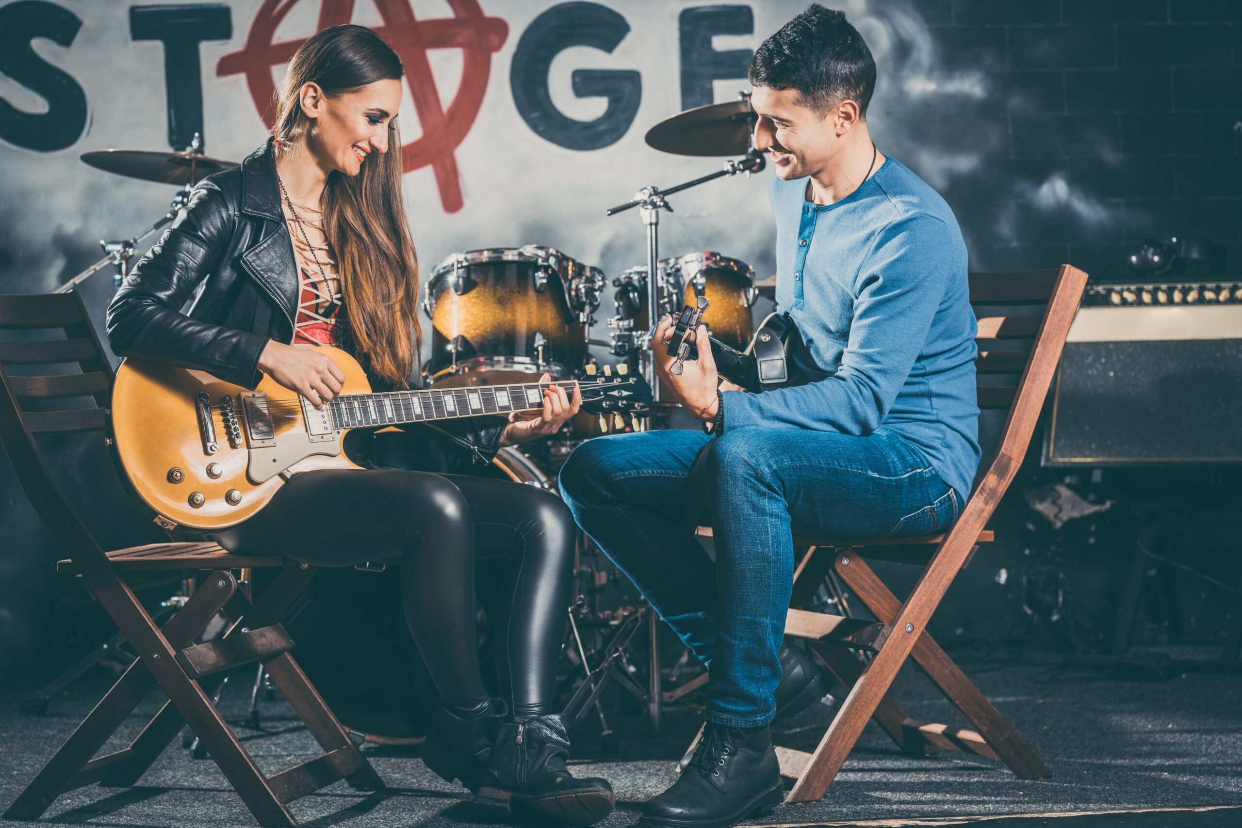 Woman taking guitar lessons with music teacher