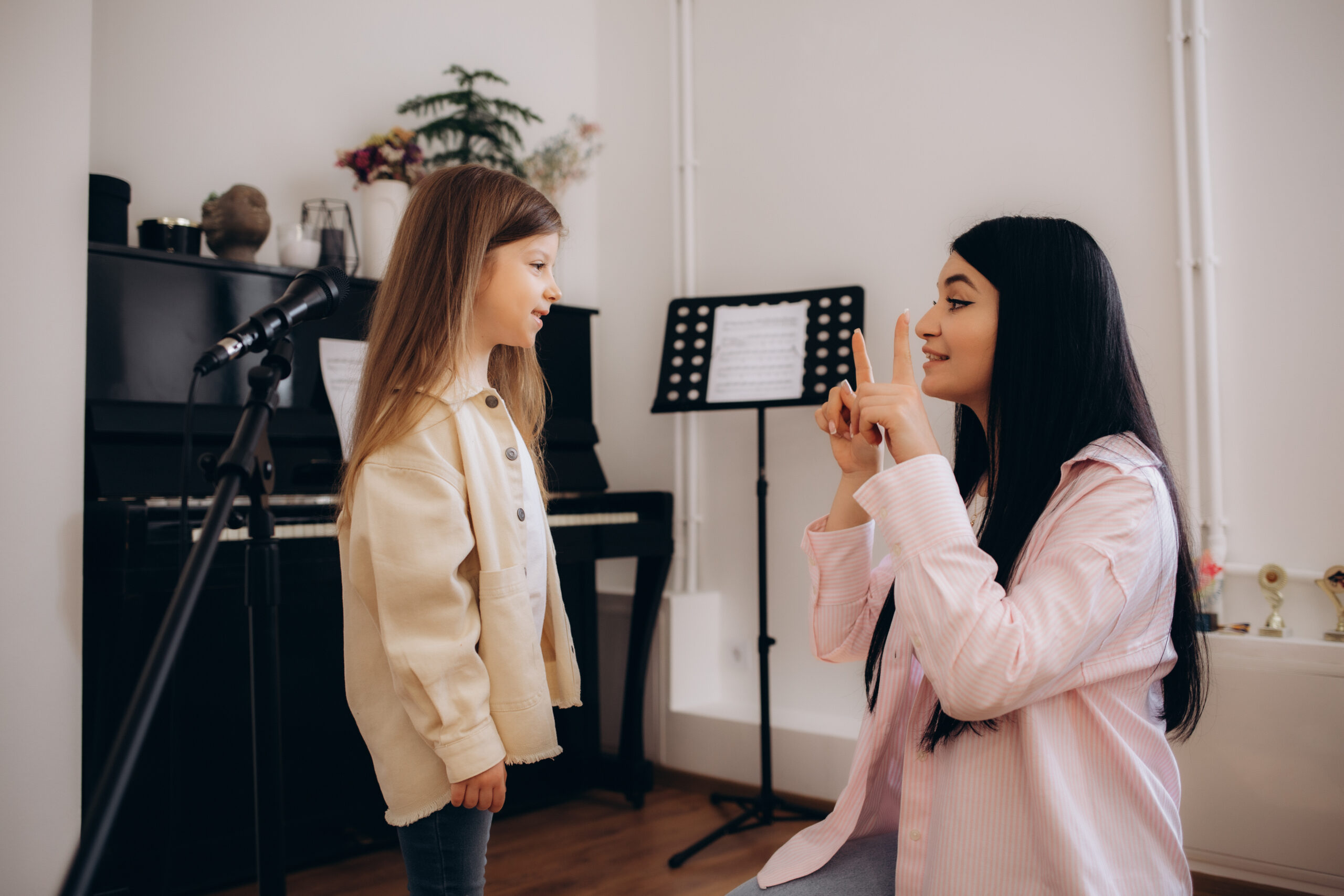 a little girl with a teacher at singing lessons