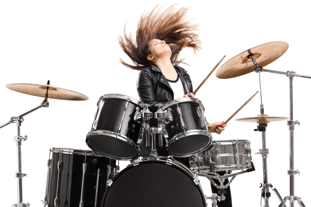 Young female drummer throwing her hair and playing drums