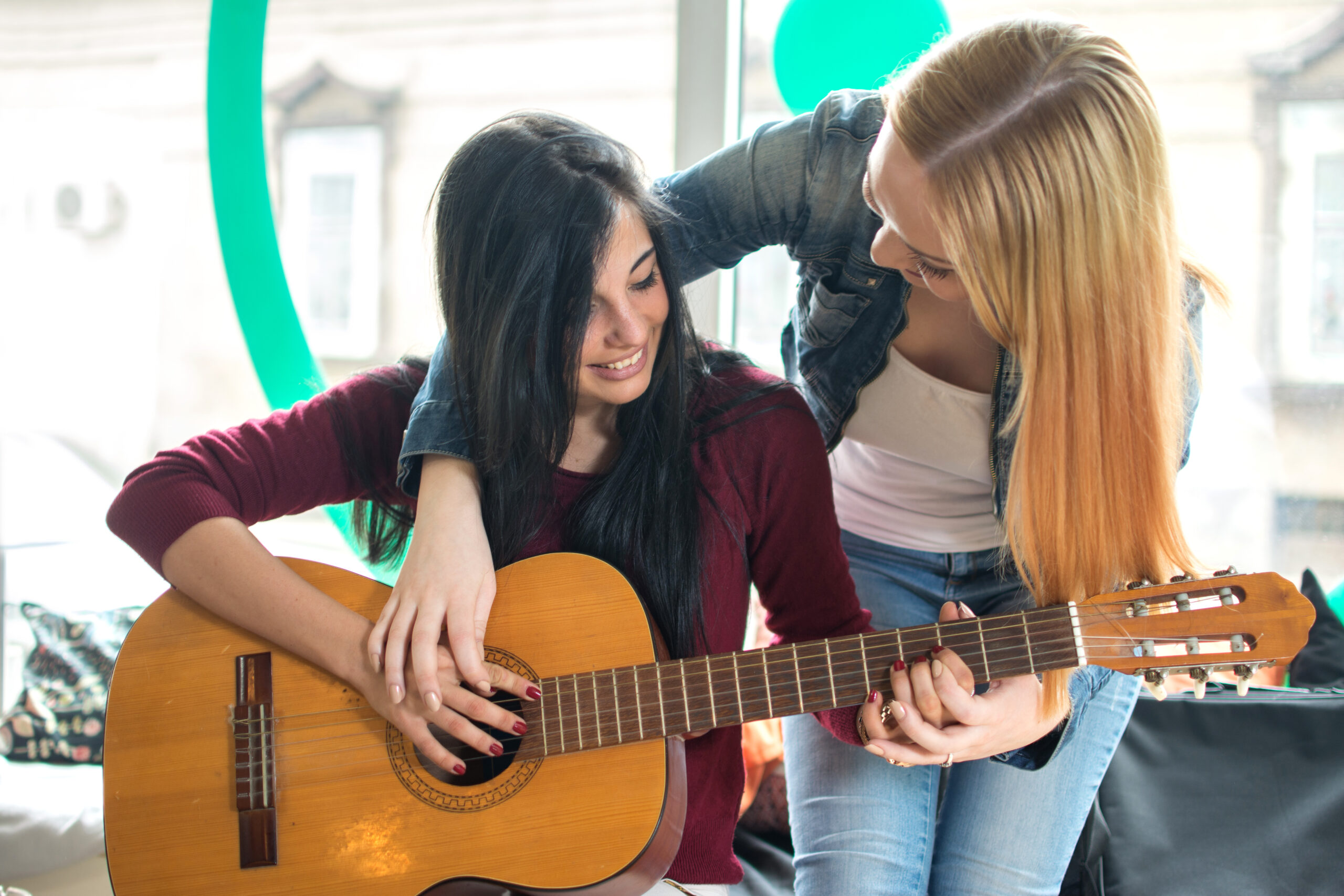 Young female teaching to play guitar.