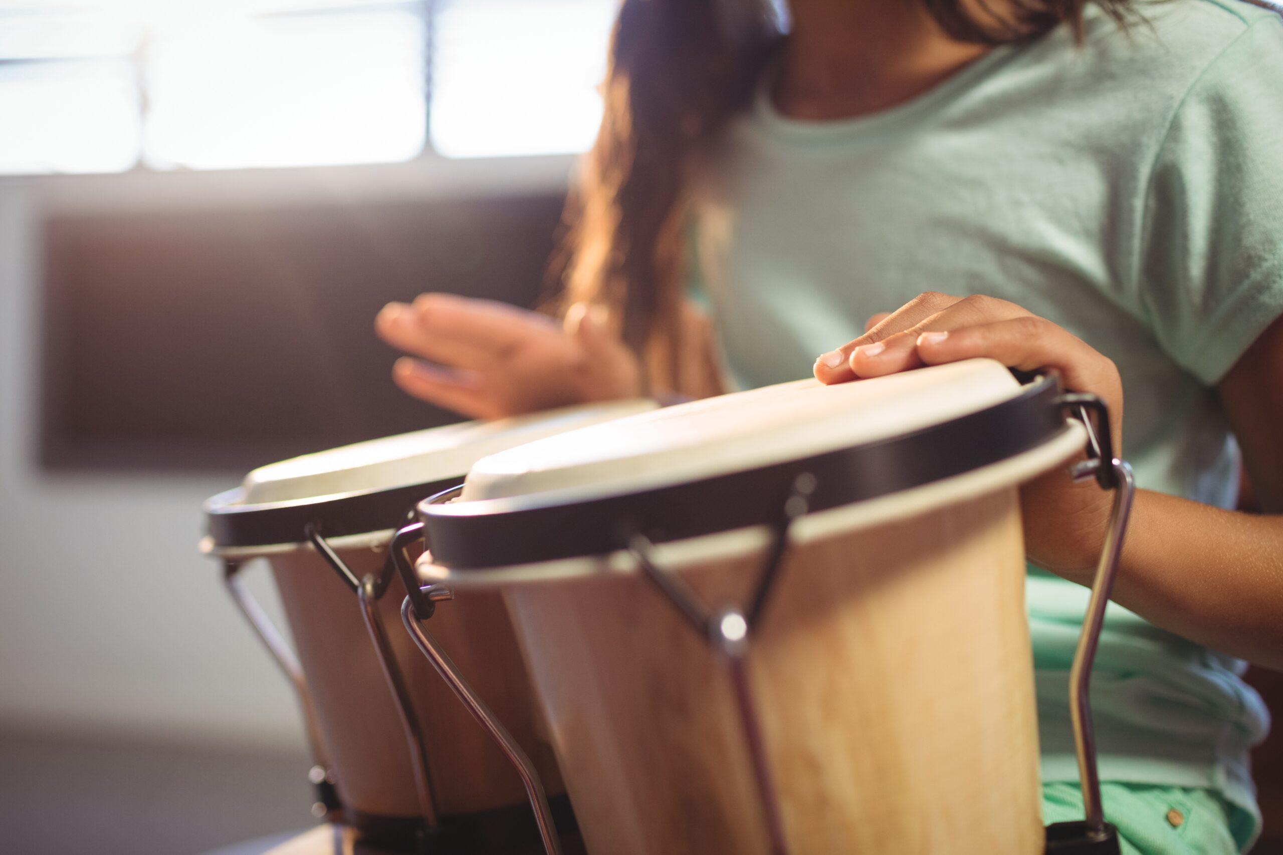 girl playing bongo drums in classroom