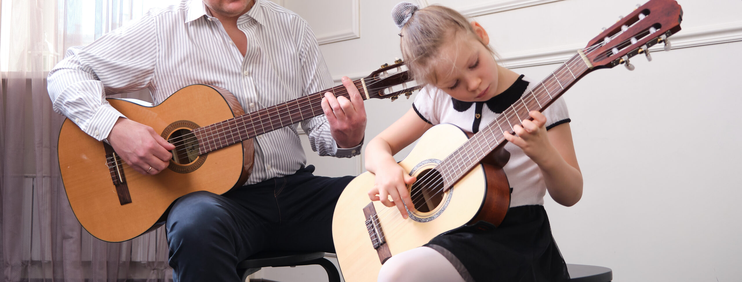 little girl learning to play the guitar